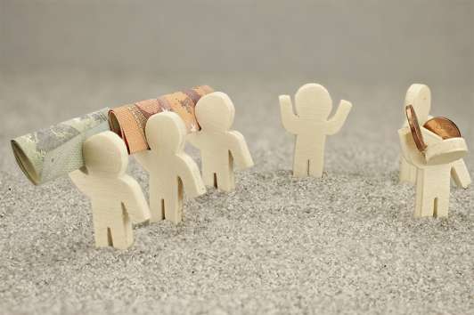 Foto: Kleine Figuren mit Geldscheinen und Münzen